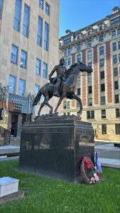 Equestrian statue outside the Harrison County Courthouse with historical architecture in the background, featuring a wreath and flag at the base.