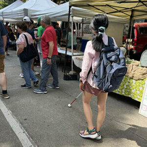 Woman walking with white cane in a crowd