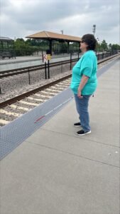 Judy near the train station with her white cane.