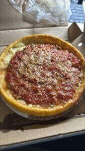 A Chicago style deep-dish pizza covered in tomato sauce.