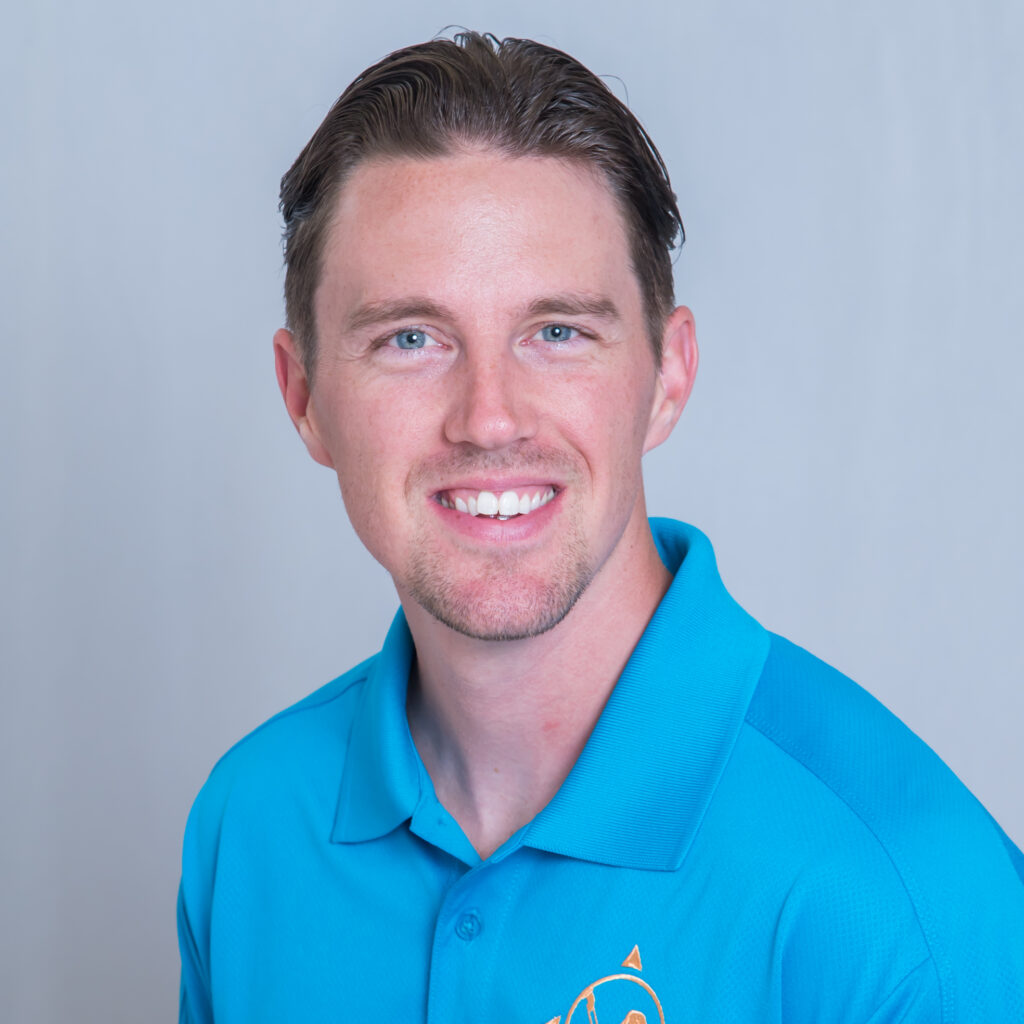 A smiling individual in a bright blue polo shirt featuring a logo.