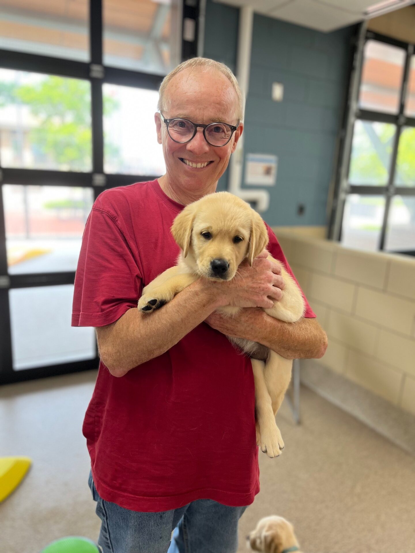 A joyful individual cradles a fluffy golden retriever puppy, showcasing a warm and playful moment.