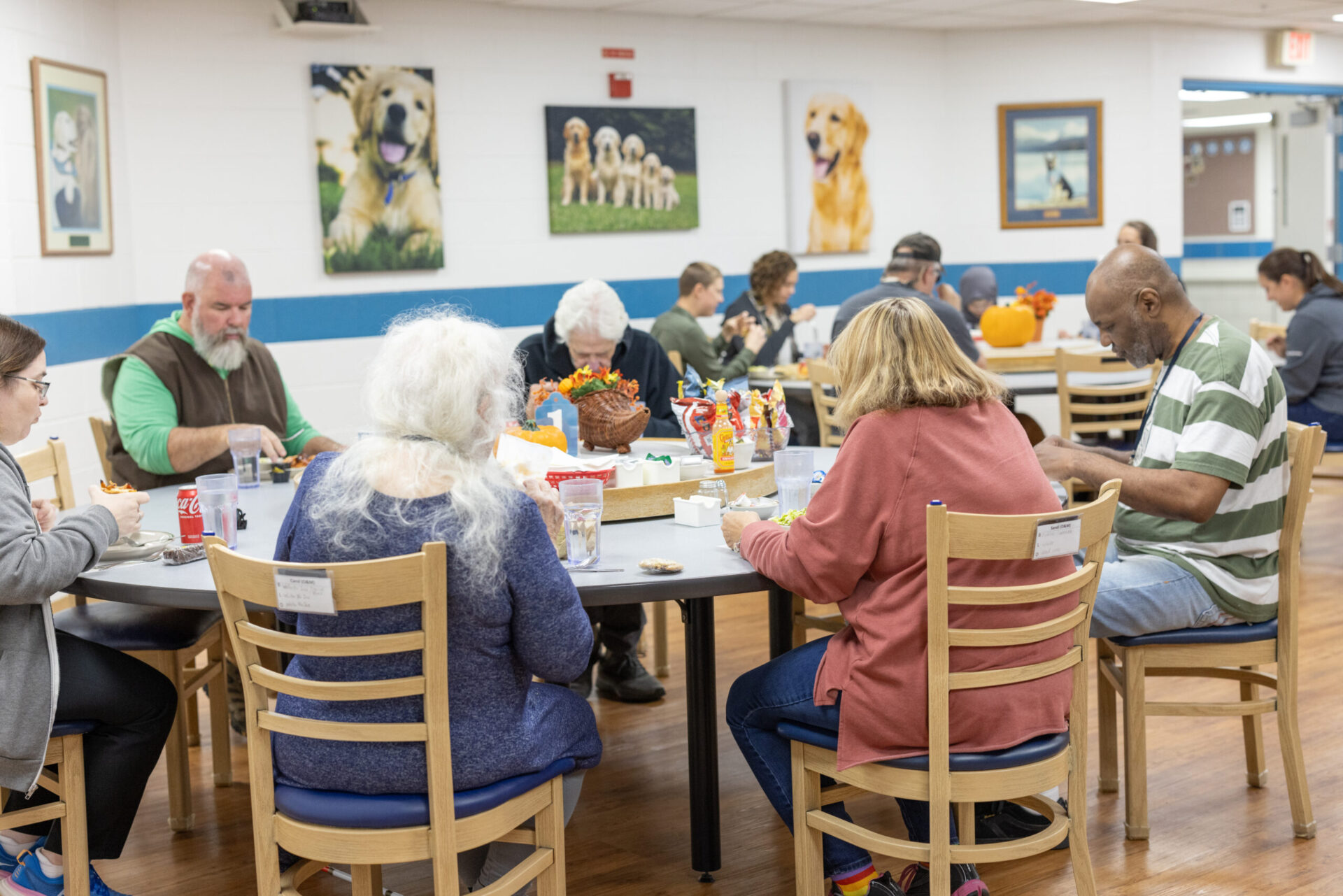 Clients seated at tables in the residence dining room.