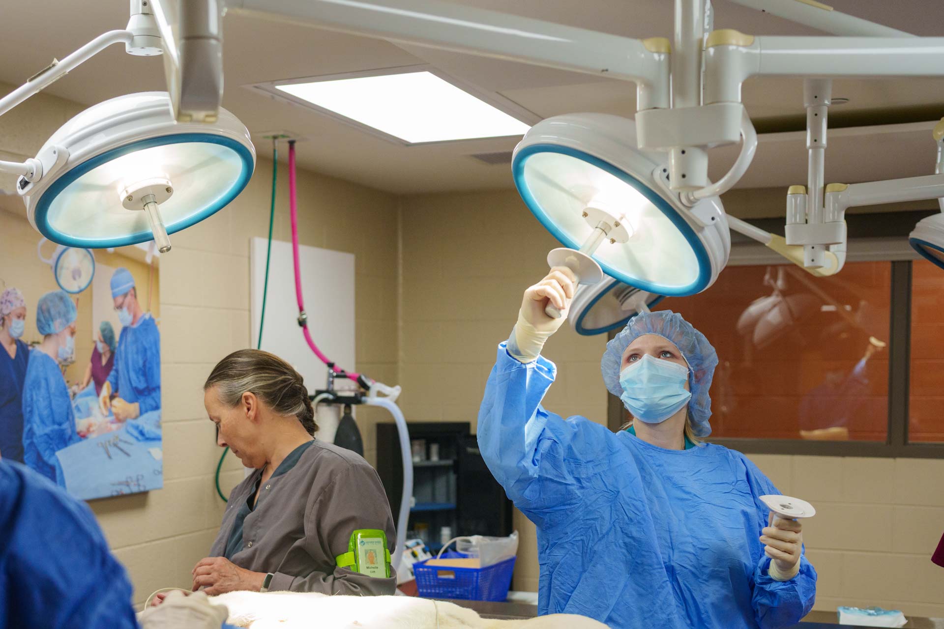Medical professionals are engaged in a surgical procedure within a well-equipped operating room.