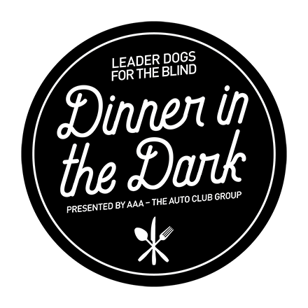 A black circle with the words "Leader Dogs for the Blind Dinner in the Dark presented by AAA - The Auto Club Group"